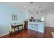 View of the dining area with a table, chairs, and hardwood floors, adjacent to a stylish white kitchen at 2134 Landfall Way, Seabrook Island, SC 29455