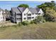 Condo building with a dark gray roof with screened in porches on each floor overlooking grassy waterfront at 2134 Landfall Way, Seabrook Island, SC 29455