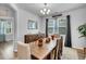 Bright dining room features a wooden table, window, stylish chandelier, and attractive natural lighting at 214 Squire Pope Rd, Summerville, SC 29486