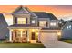 Inviting two-story home showcasing a brick and gray facade, well-manicured lawn, and a charming front porch at 214 Squire Pope Rd, Summerville, SC 29486