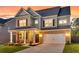 Inviting two-story home showcasing a brick and gray facade, well-manicured lawn, and a charming front porch at 214 Squire Pope Rd, Summerville, SC 29486