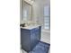 Charming bathroom with a navy vanity, white countertop, and a window with plantation shutters for natural light at 2194 Cultura Cir, Mount Pleasant, SC 29466