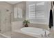 Well-lit bathroom featuring a glass shower, soaking tub, and tiled walls at 2194 Cultura Cir, Mount Pleasant, SC 29466