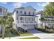 Beautiful two-story home boasts a welcoming front porch, elevated design, and picturesque landscaping at 2194 Cultura Cir, Mount Pleasant, SC 29466