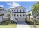 Stunning two-story beach home featuring a classic white exterior, a charming front porch, and lush tropical landscaping at 2194 Cultura Cir, Mount Pleasant, SC 29466