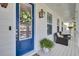 Inviting front porch with a blue door and wreath, complemented by comfortable seating and decorative accents at 2194 Cultura Cir, Mount Pleasant, SC 29466