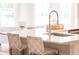 Elegant kitchen island featuring a stainless steel sink and gooseneck faucet, with seating and woven chairs at 224 Callibluff Dr, Summerville, SC 29486