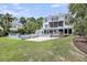 Spacious backyard featuring a pool, hot tub, lush landscaping, and an elegant two-story home at 2254 Beckenham Dr, Mount Pleasant, SC 29466