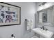 Elegant bathroom showcasing a pedestal sink, decorative mirror, and modern light fixtures and a framed artwork at 2254 Beckenham Dr, Mount Pleasant, SC 29466