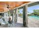 View from a covered patio showcasing elegant seating, ceiling fans, and a pool with serene landscaping at 2254 Beckenham Dr, Mount Pleasant, SC 29466