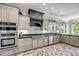 Well-equipped kitchen boasts brick floors, custom cabinets, stainless steel appliances, and modern lighting at 2254 Beckenham Dr, Mount Pleasant, SC 29466