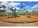 Community playground featuring modern play equipment and a soft, safe ground covering surrounded by mature palm trees at 2254 Beckenham Dr, Mount Pleasant, SC 29466
