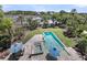 Aerial view of a backyard pool and spa, with blue umbrellas, surrounded by lush landscaping and waterfront views at 2254 Beckenham Dr, Mount Pleasant, SC 29466