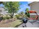 Tranquil backyard space with a grill and outdoor seating area under an orange umbrella, surrounded by greenery and a fence at 2636 Colonel Harrison Dr, Johns Island, SC 29455