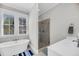 Elegant bathroom featuring soaking tub, shower with glass door, double windows and white countertops at 2636 Colonel Harrison Dr, Johns Island, SC 29455