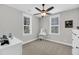 Neutral bedroom with a ceiling fan, two windows, and white vanity with stool at 2636 Colonel Harrison Dr, Johns Island, SC 29455