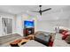 Bright living room featuring, a ceiling fan, TV with beach scene, staircase access, neutral walls, sofa and wood grain flooring at 2636 Colonel Harrison Dr, Johns Island, SC 29455