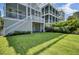Lush green backyard featuring a well-maintained lawn and the home's exterior at 30 Yacht Harbor Ct, Isle of Palms, SC 29451