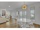 Elegant dining room with modern chandelier, white table, and views of the neighborhood at 30 Yacht Harbor Ct, Isle of Palms, SC 29451