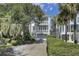Stunning two-story home featuring dual balconies, a private driveway, and mature landscaping at 30 Yacht Harbor Ct, Isle of Palms, SC 29451