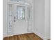 Stylish front door with decorative glass, side windows, and white trim, complements the hardwood floors at 30 Yacht Harbor Ct, Isle of Palms, SC 29451