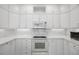 White kitchen with tiled backsplash and matching white appliances at 30 Yacht Harbor Ct, Isle of Palms, SC 29451