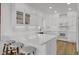 Well-lit white kitchen features quartz counters, hardwood floors, and stainless steel appliances at 30 Yacht Harbor Ct, Isle of Palms, SC 29451