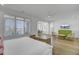 Bright bedroom features large windows, hardwood floors, and a sitting area with wicker chairs at 30 Yacht Harbor Ct, Isle of Palms, SC 29451