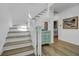 Bright staircase with wooden treads, white risers and a decorative console table leading to the upper level at 30 Yacht Harbor Ct, Isle of Palms, SC 29451