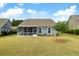 Large backyard with a screened porch, lush green lawn, and young tree, offering a serene outdoor space at 3061 Cross Vine Ln, Summerville, SC 29483