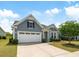 Attractive home features a two-car garage, lovely landscaping, and neutral gray siding at 3061 Cross Vine Ln, Summerville, SC 29483