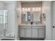 Bathroom featuring double sinks, modern mirrors, and a glass-enclosed shower at 312 Cypress Branch Rd, Huger, SC 29450