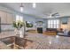 Open concept kitchen featuring a granite-topped island with stainless steel sink and modern faucet at 312 Cypress Branch Rd, Huger, SC 29450