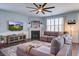 Cozy living room with a fireplace, large sectional sofa, and a ceiling fan at 312 Cypress Branch Rd, Huger, SC 29450