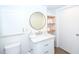 Bathroom with a white vanity, round mirror, and floating shelves for storage at 330 Concord St # 4A, Charleston, SC 29401
