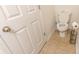 Cozy half bath with tile floor, toilet, and white door at 333 Flyway Rd, Goose Creek, SC 29445