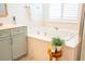 Bright bathroom featuring a soaking tub with a white countertop, shutters, and a light blue vanity at 3439 Toomer Kiln Cir, Mount Pleasant, SC 29466