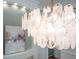 Close-up shot of a modern chandelier and a glimpse of the dining room decor at 3439 Toomer Kiln Cir, Mount Pleasant, SC 29466