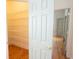Open closet with white wire shelving, hardwood floors, and a view of the neutral bedroom through the doorway at 3439 Toomer Kiln Cir, Mount Pleasant, SC 29466