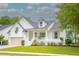 Charming white two-story home with inviting front porch and well-manicured lawn at 3439 Toomer Kiln Cir, Mount Pleasant, SC 29466