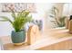 Close-up of a stylish home office desk with a potted plant and decorative clock at 3439 Toomer Kiln Cir, Mount Pleasant, SC 29466