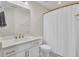 Bright bathroom features a single sink with white cabinets and brushed gold hardware and shower with white curtain at 3990 Hillyard St, North Charleston, SC 29405