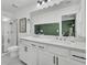 Bright bathroom with dual sinks, white cabinets with black hardware, and walk-in shower with glass enclosure at 3990 Hillyard St, North Charleston, SC 29405