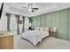 Bright bedroom features a ceiling fan, large windows, wood paneled accent wall and queen size bed with white linens at 3990 Hillyard St, North Charleston, SC 29405