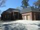Stunning new construction home featuring a brick facade and three-car wooden garage doors at 404 Fairington Dr, Summerville, SC 29485