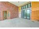 Large sunroom with brick wall, glass doors, unfinished wood paneling and concrete flooring at 404 Fairington Dr, Summerville, SC 29485