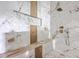 Close-up of a shower showcasing marble tiling, wood accents, sleek fixtures, and a built-in shelf at 404 Fairington Dr, Summerville, SC 29485
