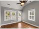 Serene bedroom featuring a ceiling fan, multiple windows, and access to a private outdoor balcony at 407 Pitt St, Mount Pleasant, SC 29464