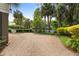 Gravel driveway featuring tropical landscaping and a charming white picket fence outlining the property at 407 Pitt St, Mount Pleasant, SC 29464