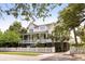 Inviting two-story home with a front porch, white picket fence and lush landscaping at 407 Pitt St, Mount Pleasant, SC 29464